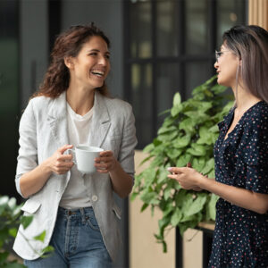Two woman talking in front of a building.