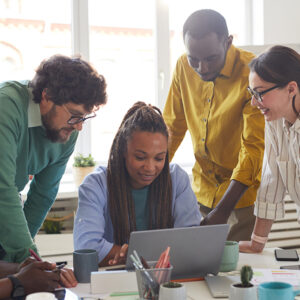 Four team members collaborating around a laptop.