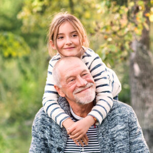 Grandfather giving granddaughter a piggy back ride
