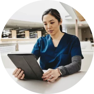 A female medical professional looking at a tablet.
